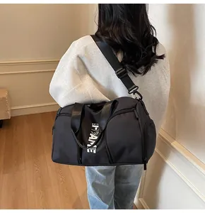 Dettaglio borsa sportiva in nylon nero capiente con tracolla regolabile e manici