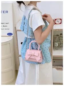 Roze mini crossbody tas met grote strik en elegante zilveren metalen kettingriem