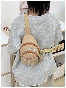 Detail of khaki nylon chest bag with white letter print and graphic zipper pocket