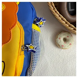 Detail shot of the star-shaped zipper pull on a colorful cartoon lion backpack