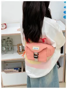Rear view of a child wearing a pink canvas chest bag with adjustable beige strap