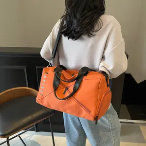 Detalle de la bolsa deportiva naranja con bolsillos con cremallera y correa de hombro