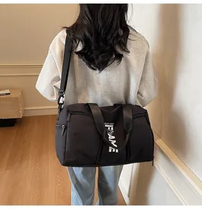 Vista posteriore dettagliata di una borsa sportiva nera con stampa di lettere e tracolla