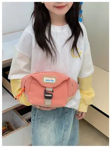 Detail of pink canvas kids fanny pack showing branded label and orange zipper pull cord