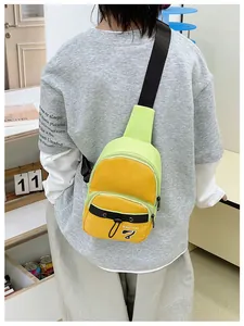 Close-up of a mini crossbody chest bag in neon green and orange with adjustable strap