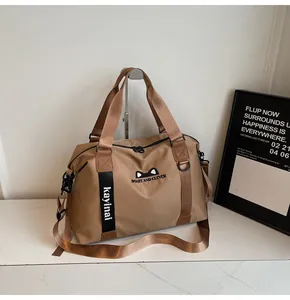 Detail of khaki nylon travel bag showing cat ears design and adjustable wide shoulder strap