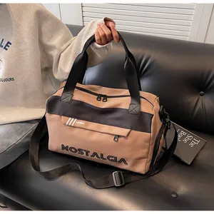 Detailed view of the large capacity khaki travel bag with nostalgia lettering on a sofa