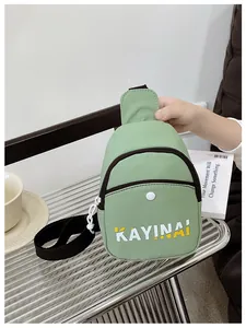 Gros plan d'un sac bandoulière vert clair avec lettres blanches et sangle noire
