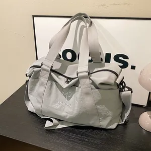 Dettaglio borsa da viaggio grigia con ricamo MP MOPPO bianco e tracolla staccabile inclusa