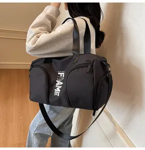 Borsa sportiva nera con tracolla regolabile mostrata su un modello femminile in casa