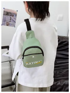 Vue détaillée du dos d'un sac à bandoulière vert clair pour garçon avec sangle noire