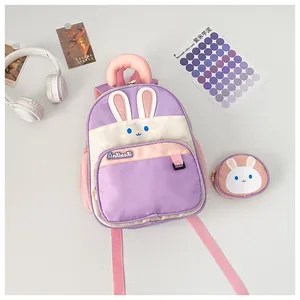 Detail view of cartoon rabbit backpack in purple and white with matching small coin purse