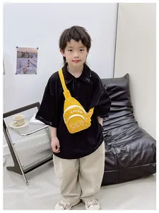 Detail of yellow canvas kids chest bag with letter print worn by boy in casual setting