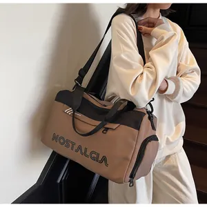Detail of large travel tote with NOSTALGIA lettering and side zipper pocket