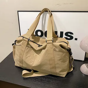 Dettaglio della borsa da viaggio kaki con trama impermeabile e manici robusti