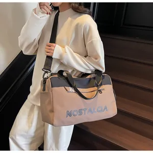 Detail of khaki travel tote with NOSTALGIA lettering and adjustable black shoulder strap