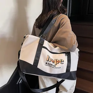 Large capacity canvas travel tote with letters and contrast shoulder strap on model