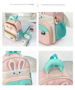 Detail of pink cartoon rabbit backpack showing heart zippers, mesh pocket and embroidery