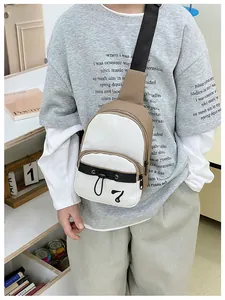 Detail of canvas crossbody bag showing contrast panels and drawstring pocket with number 7