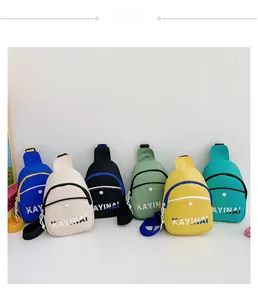 Détail de sacs bandoulière en toile colorée pour garçons avec imprimé lettres et poches