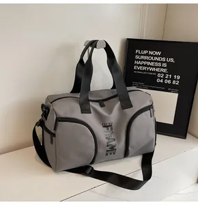 Dettaglio macro della borsa fitness in nylon grigio con tasche frontali e logo Kayinai
