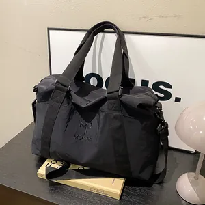 Dettaglio borsa da viaggio nera con ricamo MOPPO e tracolla regolabile e rimovibile