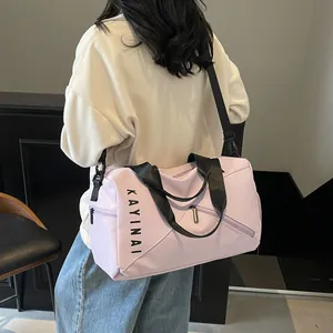 Detalle de bolsa de viaje lila con correa negra y compartimento para ropa húmeda