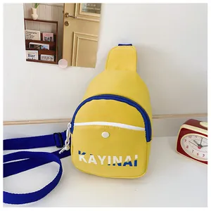 Détail du sac bandoulière en toile jaune avec lettrage bleu et fermeture éclair marine