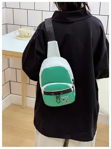 Detail shot of mini crossbody chest bag in green and white with Kayinai logo and strap