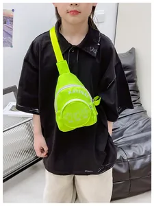 Kids neon green canvas chest bag with white letter print shown on a young model