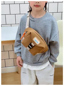 Close-up of brown canvas kids chest bag featuring orange zipper and KAYINAI leather patch
