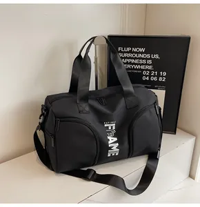 Dettaglio borsa sportiva nera con stampa FAME, tasche laterali e ampia tracolla regolabile