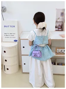 Detail van lavendel mini crossbody tas voor kinderen met strik en zilveren ketting