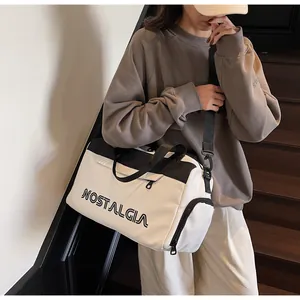 Detail of black and white travel bag with NOSTALGIA lettering and side storage compartment