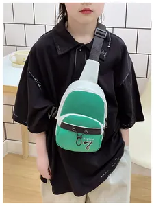 Detail of green and white color-block kids crossbody bag with adjustable black strap