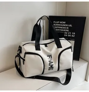 Dettaglio borsa sportiva in nylon bianco con cinghie nere e tasche frontali con zip