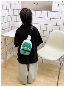 Detail of green and white color-block kids crossbody bag with adjustable strap