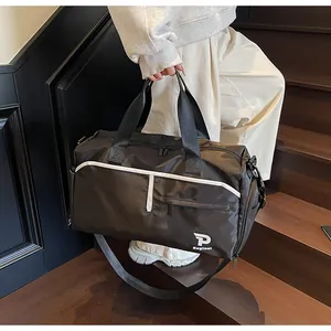 Detalle de bolsa de deporte negra grande con logo blanco y correa ajustable en la escalera