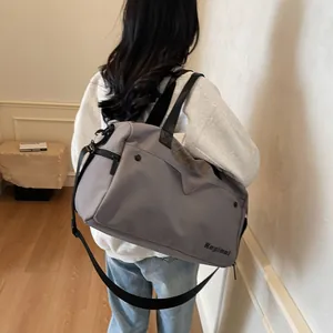 Detail van de mauve nylon reistas met grote capaciteit en verstelbare zwarte schouderriem