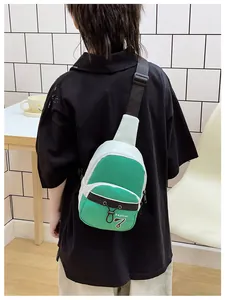 Detail view of the green and white contrast crossbody bag worn on a person's back