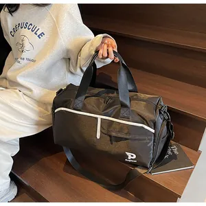 Detalle de bolsa de viaje negra impermeable con ribetes blancos y asas de mano dobles