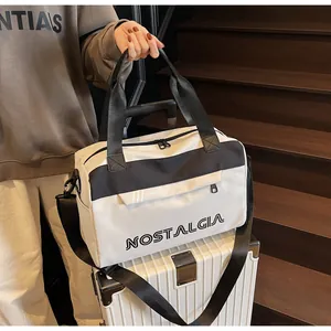 Detail of large travel tote bag with NOSTALGIA print on a white suitcase