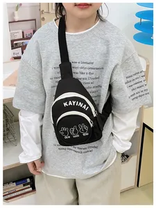 Close-up of black canvas chest bag for kids with adjustable strap and graphic prints