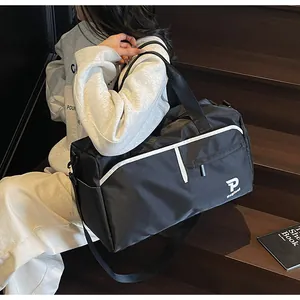 Detalle de bolsa deportiva de nailon impermeable con ribete blanco y correa en modelo