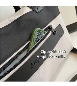 Detail of the front zipper pocket on canvas travel bag holding a smartphone for scale