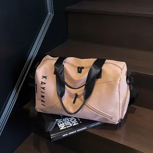 Detalle de bolsa de viaje rosa en tela impermeable sobre una escalera de madera