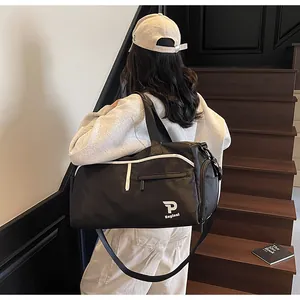 Detalle de bolsa de deporte negra con logo de marca blanco y correa de hombro ajustable