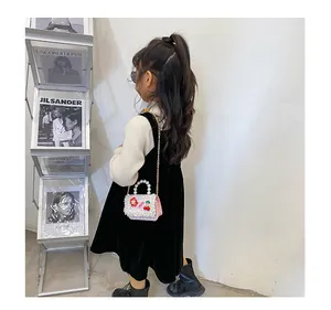 Détail du sac tissé en perles roses et blanches pour filles avec fleurs et cerises déco