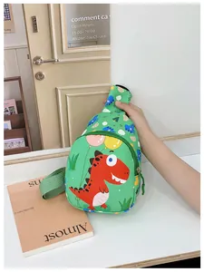 Detail der grünen Kinder-Brusttasche mit rotem Cartoon-Dinosaurier und Tragegurt