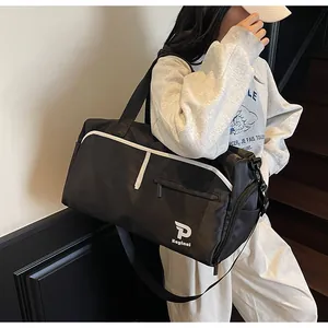Detalle del tejido de nailon impermeable y el logo P Kayinai en el bolso de viaje negro